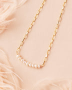 delicate pearl and gold filled paperclip necklace with pearls displayed flat on cream backdrop