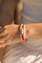 Model wearing the Ombre Bracelet in Rosé with semiprecious stones, pearl centrepiece, and gold-filled beads as well as the balance bracelet (pink semiprecious stones and freshwater pearls) and the embrace bracelet with freshwater pearls and semiprecious stones in cinnamon.