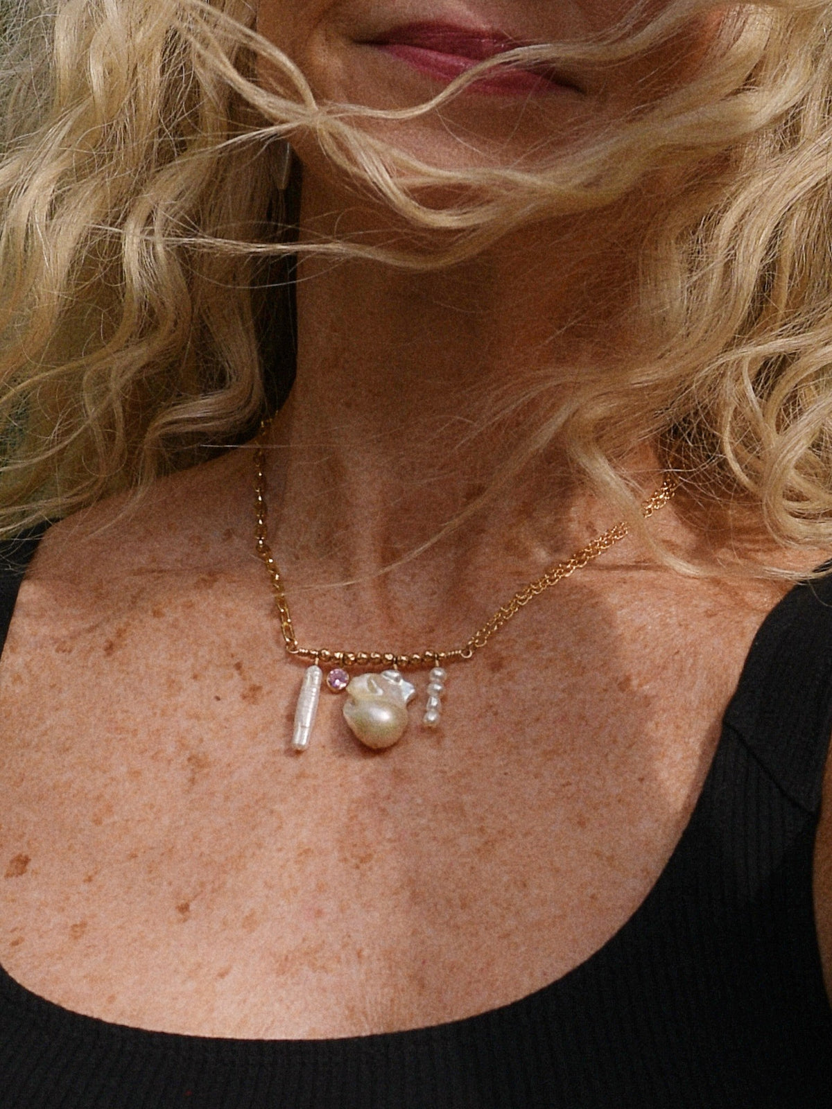 The Icon Necklace with a pink stone, worn with a black tank