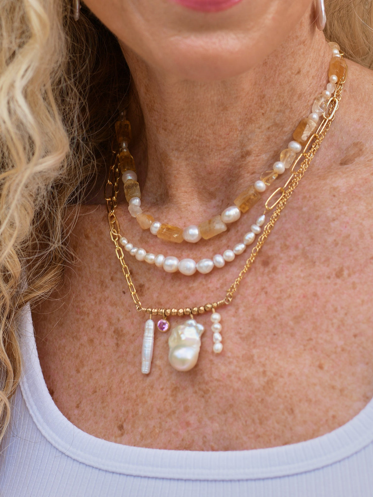 Icon, Pearl Forte and Soleil necklaces layered, worn with a white tank