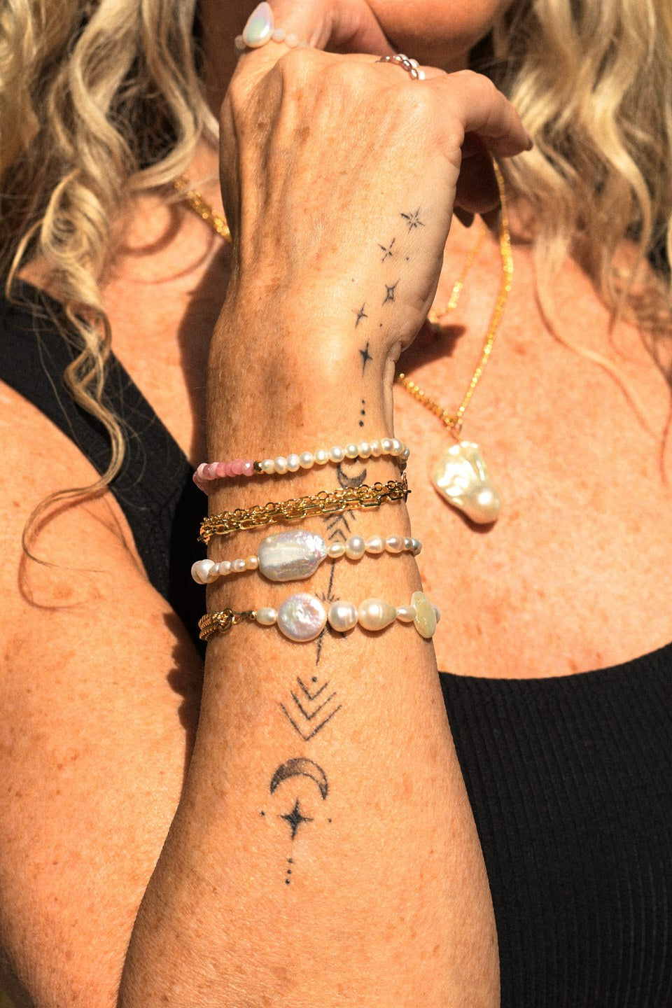 Sloane, Horizon, Aria and Balance bracelets stacked on the wrist, with the Aura Necklace